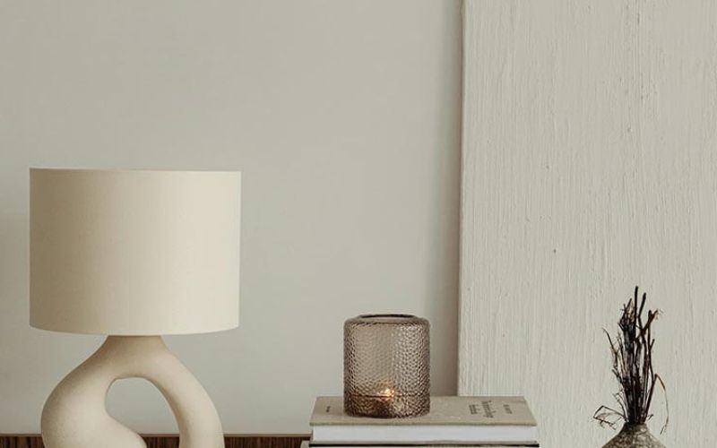 Minimalist home decor arrangement featuring a cream-colored table lamp